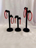 Aurora Collection Siam Red skinny hoop earrings featuring vibrant red performance crystals on a black velvet jewelry display.