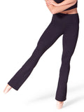 Front three-quarter view of a fitness model wearing black Capezio® Soft Elegance Flare Leggings with ballet shoes, showcasing the high-waisted fit and leg flare.