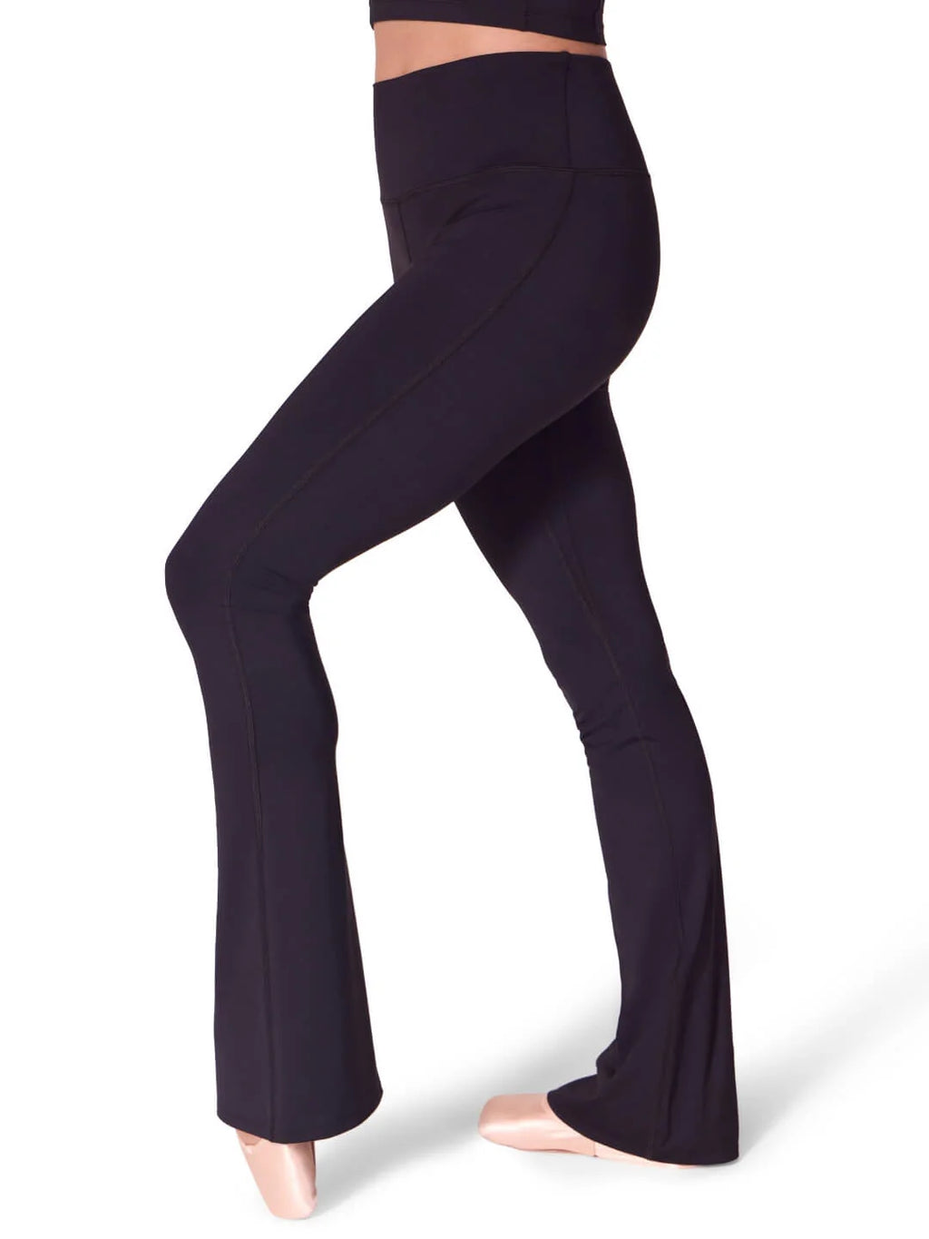 Side profile view of a model wearing the black Capezio® EL112W flare leggings, highlighting the supportive self-lined waistband and sleek thigh-to-calf compression.