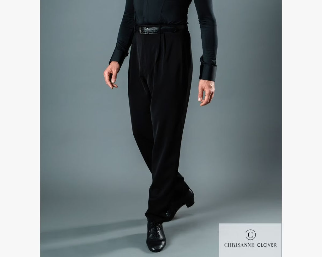 Close-up lower body view of a male dancer posing in black Chrisanne Clover Latin practice trousers and black Cuban heel Latin shoes against a grey background.