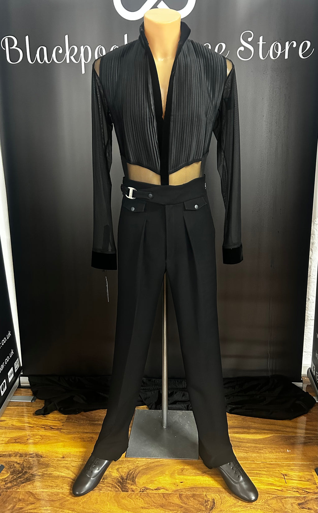 Pure Class Mark Shirt featuring pleated black velvet front bodice and sheer mesh sleeves on a showroom mannequin with high waisted Latin dance trousers at Blackpool Dance Store.