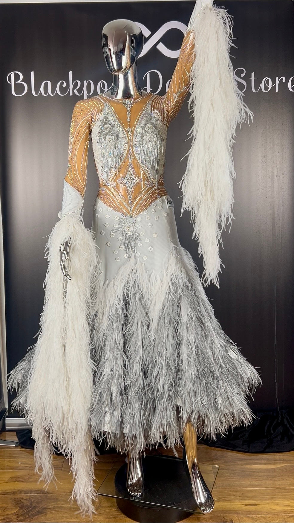 Front view of a luxury white and silver feathered ballroom competition dress by Nordin Exclusive Designs.