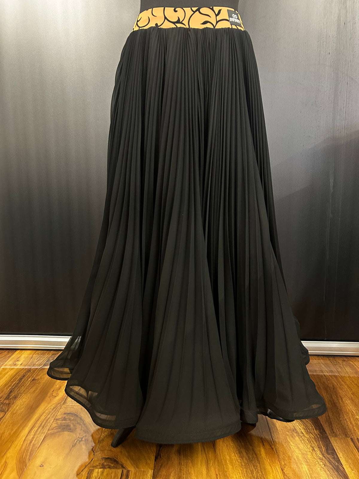Essentials pleated classical sequence skirt in black. Photo is indicative: waistband shown was a one-off to match a customer's bodice; online orders receive a solid colour-matched waistband.