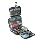 Black International Dance Shoes hanging Essentials Bag opened up to showcase four clear travel organizer compartments filled with dance cosmetics.