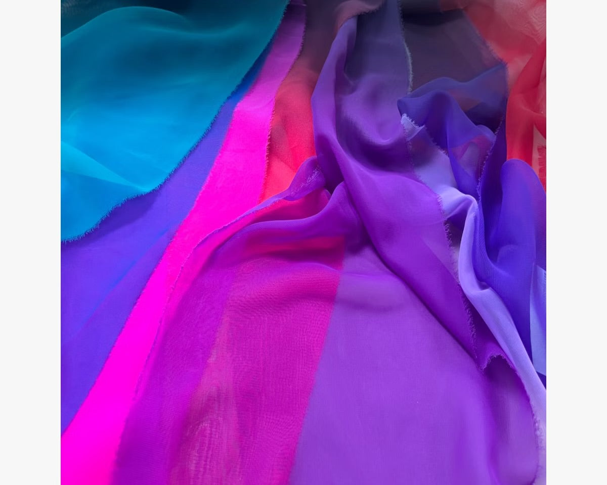 A draped display of vibrant Chrisanne Clover Luxury Georgette fabric in high-saturation Aqua and Orange, showcasing its fine matte texture and lightweight fluid movement.